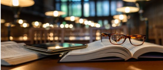digital-tablet-and-eyeglasses-on-books-in-public-library-picture-id1135144614